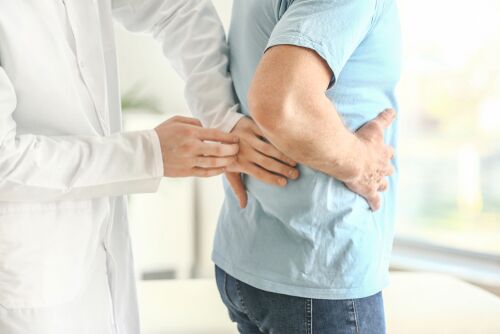 A healthcare professional examines the lower back of a person