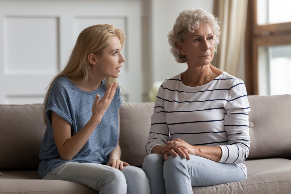 A young woman appears to be talking to an older woman who looks away